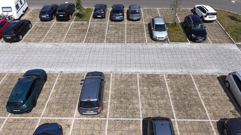 parking z ekokraty z wyznaczonymi miejscami postojowymi i zaparkowanymi samochodami
