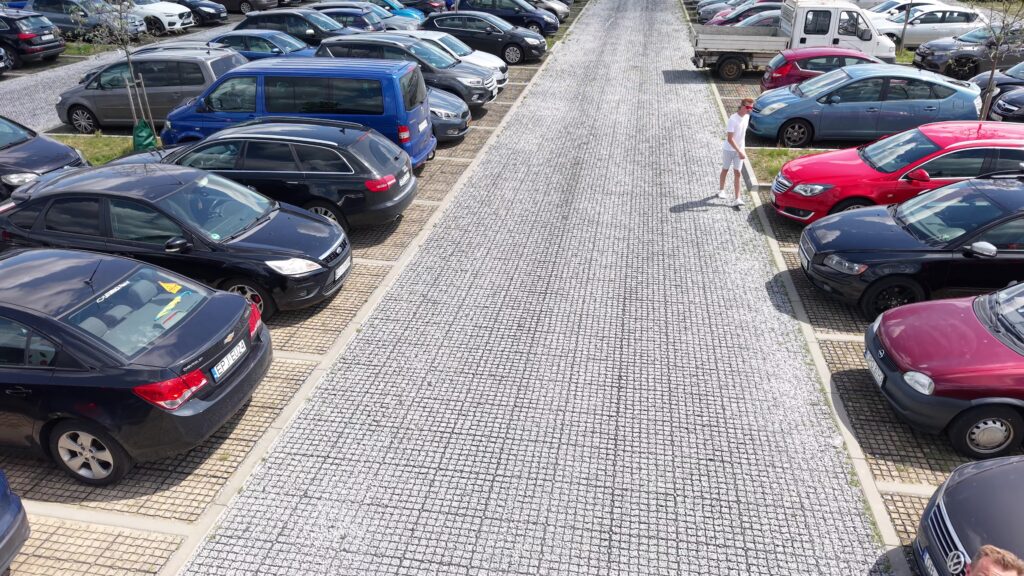 duży parking z ekokraty z drogą przejazdową i samochodami po obu stronach