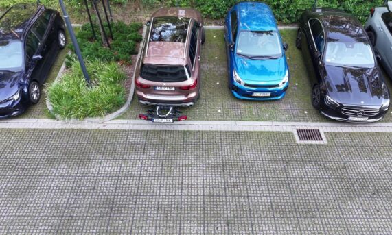 miejsca parkingowe z ekokraty przy budynku apartamentowym i pergoli rowerowej