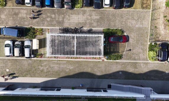 nawierzchnia z ekokraty przy pergoli rowerowej na terenie apartamentów