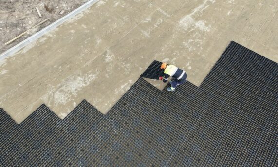 ładowarka przewożąca paletę ekokraty N40 PLUS na placu budowy w Toruniu